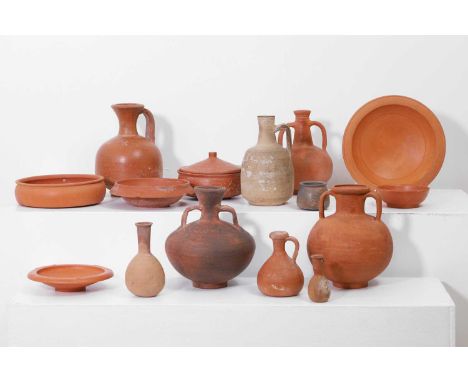 A large collection of Roman terra sigillata pottery vessels, comprising variously sized dishes and bottles, some with moulded