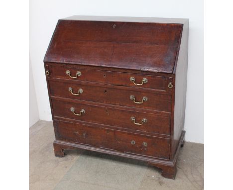 An 18th century oak bureau, with a sloping fall enclosing a fitted interior of pigeon holes and drawers, above four long grad