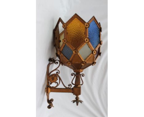 A wall light with coloured glass panels, on a scrolling metal base, 65cm high 