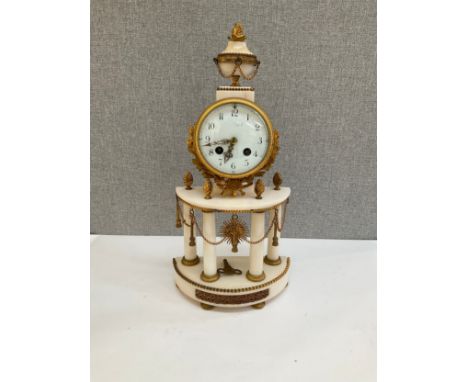 A 19th Century French alabaster and ormolu mantel clock with Arabic dial and column detail, sun-form pendulum, silk suspensio
