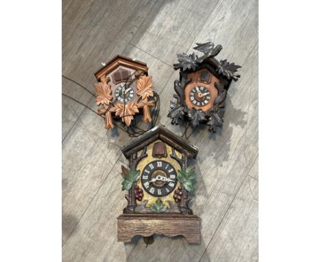 A cuckoo bracket clock together with two wall hanging examples, one with stag mount (3) 
