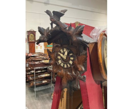 A 20th Century Black Forest cuckoo clock, surmounted by bird, 43cm tall, with pendulum and two weights 