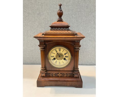 An early 20th Century walnut bracket clock, Roman dial, column detail, carved relief, with pendulum 