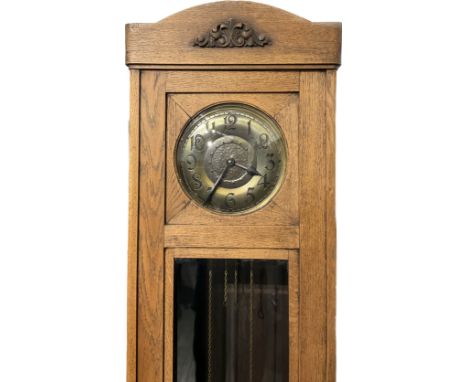 A 1920s oak long case clock with brass Arabic dial, bevelled glazing, with pendulum and weights 
