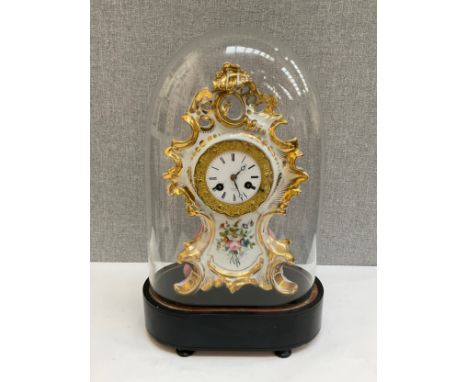 A 19th Century Valery of Paris ceramic clock enriched with gilt and floral sprays, enamel face a/f, cased under glass dome, c