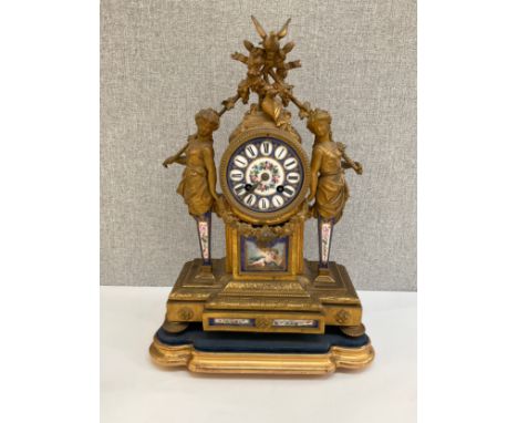 A late 19th Century French figural ormolu mantel clock, Sevres style face and panels, surmounted by wreath and doves, flanked