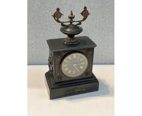 A late 19th Century black Belgian marble mantel clock surmounted by an urn with lion mask handles, enriched with gilt, corner