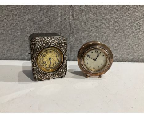 A silver fronted travelling timepiece together with a silver cased Deco clock of circular form (2) 