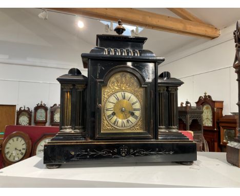 A circa 1900 ebonised wood mantel clock of architectural form, gilt brass relief surrounding Roman dial, with pendulum 