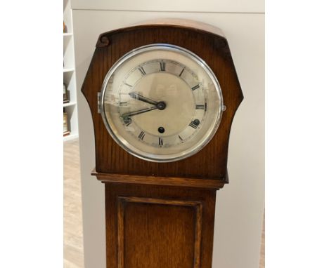 A 1920s oak cased Grandmother clock with Roman numerated metallic dial, with pendulum 