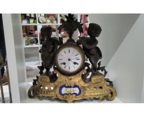 A 19th Century French spelter and ormolu figural clock with painted ceramic panel to base 