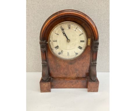 A 19th Century walnut cased mantel clock with arched top, carved sides, Roman numerated dial, Wymondham retailer label verso,