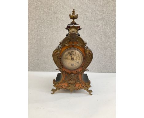 A 19th Century balloon form mantel clock, burr wood applied with scrolled ormolu front, ebonised body, Arabic dial, 30cm tall