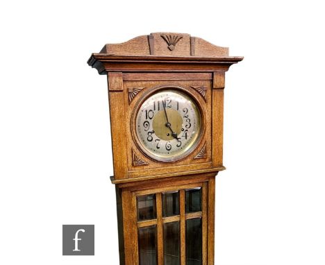 A 1930s oak longcase clock, with eight day striking movement, the circular Arabic dial over a bevelled glass panelled door on