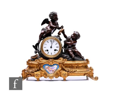 A 19th Century French bronzed spelter and gilt metal mantle clock, modelled as two cherubs playing the tambourine over an eig