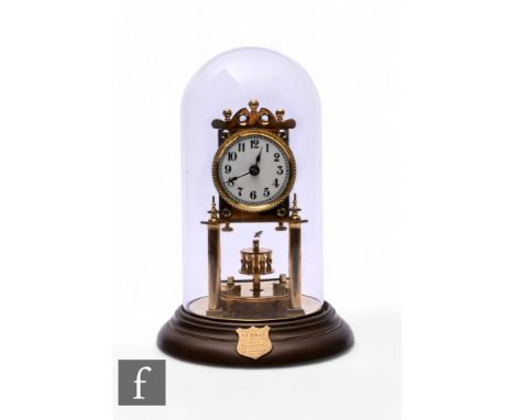 An Edwardian 365 day brass mantle clock, circular suspended pendulum below a circular Arabic dial and glass dome, with presen