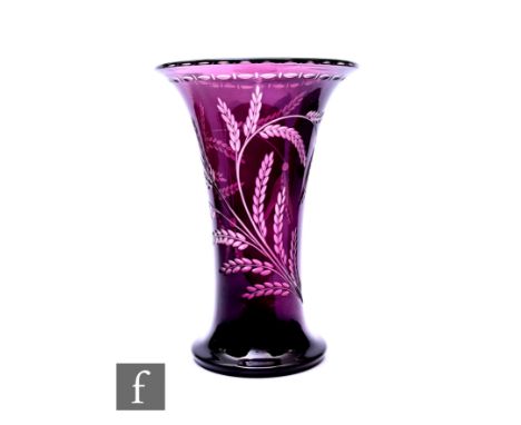 An early 20th Century flashed glass vase, of trumpet form on flared foot, amethyst over clear intaglio with grass fronds and 