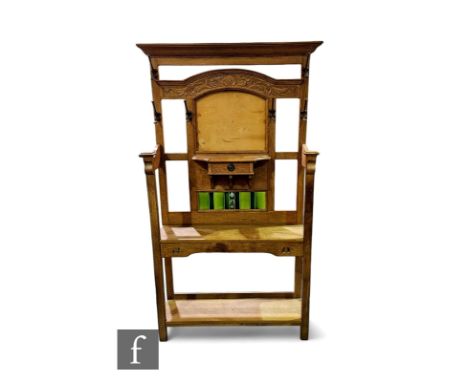 An Edwardian Art Nouveau light oak hall stand, with foliate carved cornice above an aperture for a mirror, glass missing, and