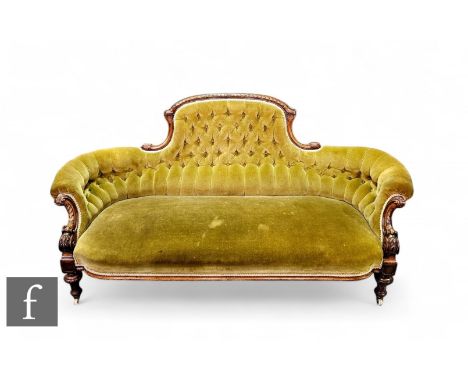 A Victorian carved walnut three seater sofa shaped back flanked by scroll arms on turned block legs and castors, upholstered 
