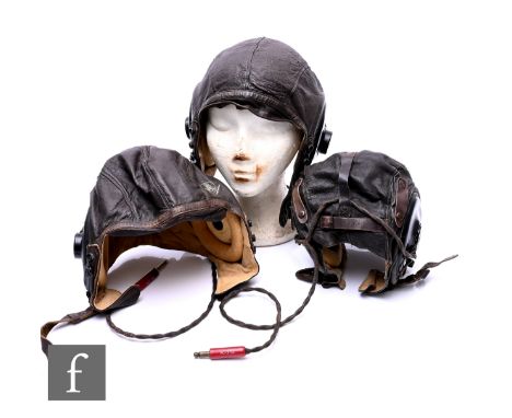 Three US Army air Forces brown leather flying helmets, each with receivers ANB-H-1 by the Shure Brothers Chicago. (3)