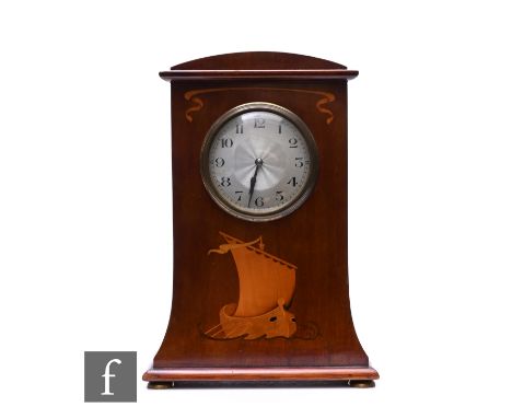 An Edwardian Art Nouveau inlaid mahogany mantle clock, decorated with a Viking ship below a circular dial, on brass ball feet