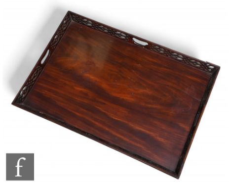 A George III mahogany fret-cut rectangular serving tray in the Chippendale style, with a pierced grip to each of the fret-cut