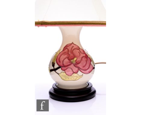 A Moorcroft Magnolia pattern lamp base, of baluster form, tubeline decorated with pink flowerheads on leafy branch over ivory