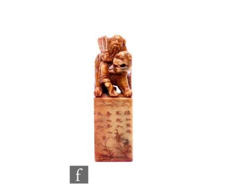 A mid 20th Chinese soapstone desk seal of block form mounted with a sage and a dog of Fo, cased, height 10cm.