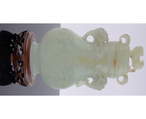 A Chinese pale green jade vase & cover,relief carved allover with dragons & scrolls, hardwood stand, height overall 7.75", (l
