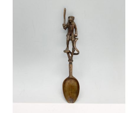 Unique utensil decorated on the tip of the handle with a long tailed monkey dressed in a coat as they hold a stick. Issued: 2