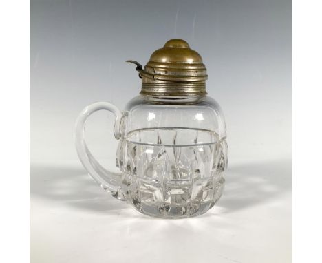 A glass syrup pitcher with a textured waffle cut pattern, a sturdy handle and a vintage bronze colored spout lid. Dimensions: