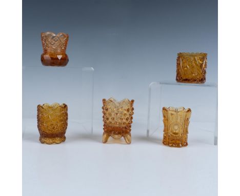 A charming set of five round amber art glass toothpick holders includes three adorned with kaleidoscope like patterns, one ho