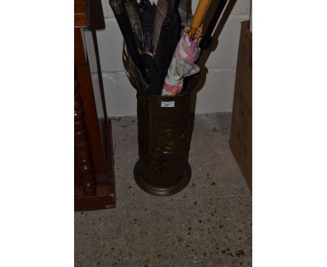 Brass stick stand containing various assorted umbrellas and  walking sticks