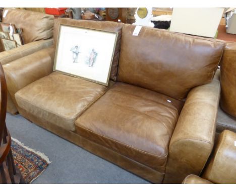 A distressed tan leather two seater sofa.