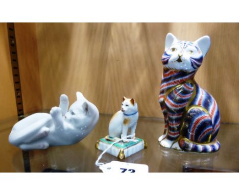 A Royal Crown Derby cat paperweight, together with a Royal Copenhagen kitten, 727, and a miniature Chelsea porcelain cat on c