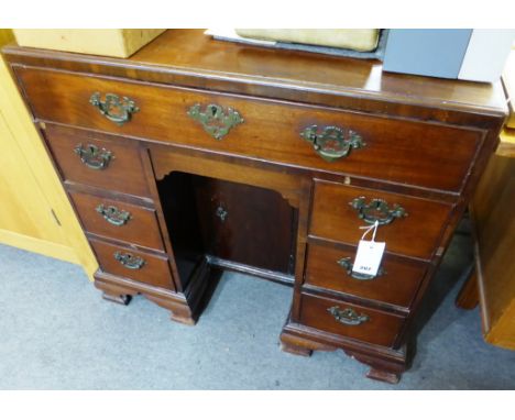 A George III mahogany kneehole dressing table, the caddy moulded top over a fitted full width top drawer with various open an