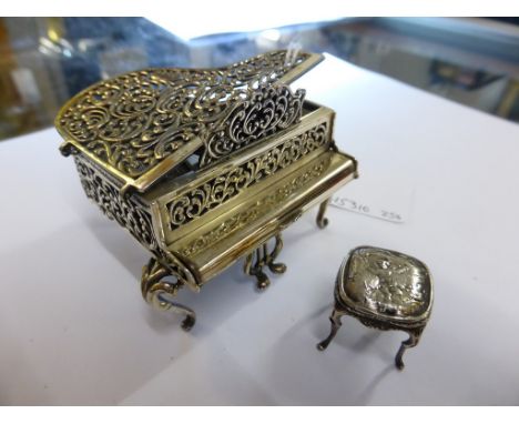 A Continental miniature silver musical grand piano and stool, the music box with clockwork key to underside, stamped 925.