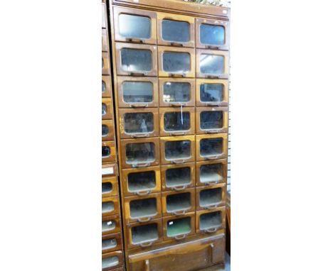 A vintage oak haberdasher's or habersdashery&nbsp;cabinet with glassfront drawers.