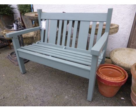 A sage green painted garden bench.