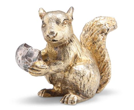 AN ELIZABETH II PARCEL-GILT SQUIRREL PAPERWEIGHT by Stuart Devlin, London 1974, holding a silver nut. 3.5cm high, 3.3 troy ou