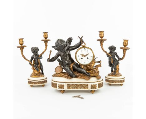 A three-piece mantle clock decorated with putti and a satyr, made of patinated and gilt spelter. The second half of the 19th 