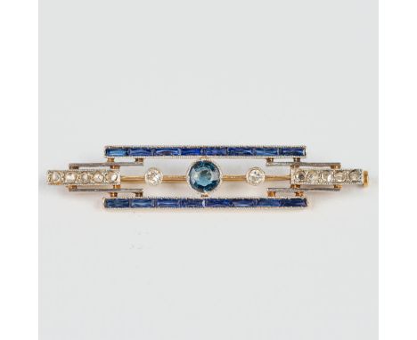A small brooch made of yellow and white gold in art deco style, with blue sapphires. The first half of the 20th century. Tota