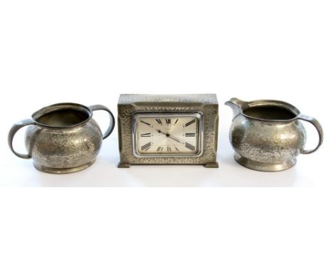 Tudric pewter planished milk jug and sugar bowl and a planished pewter 8 day mantle clock, C.P & Co (3)