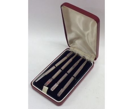 A cased set of four silver Bridge pencils with engine turned decoration. Est. £20 - £30.