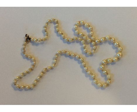 A graduated string of cultured pearls with ring clasp. Approx. 12 grams. Est. £20 - £30.