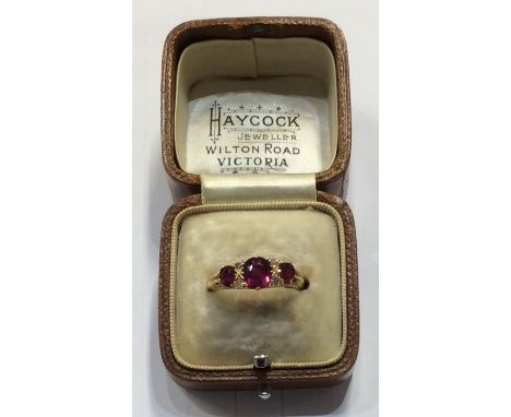 An 18 carat ruby and diamond seven stone ring in claw mount. Approx. 3.8 grams. Est. £150 - £200.