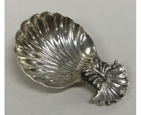 An unusual Georgian silver caddy spoon with fluted bowl and shell thumb piece. Approx. 14 grams. Est. £40 - £60.