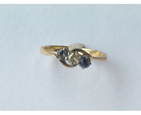 A sapphire and diamond three stone crossover ring. Approx. 2.7 grams. Est. £50 - £80.