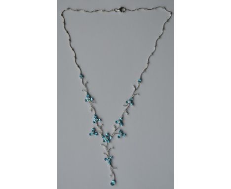 An attractive diamond and blue topaz necklet decorated with flowers and scrolls to ring clasp in 18 carat. Approx. 15.3 grams