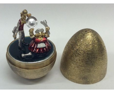 STUART DEVLIN: A cased silver and silver gilt egg of typical form depicting enamel figures. Numbered 29. Approx. 106 grams. E